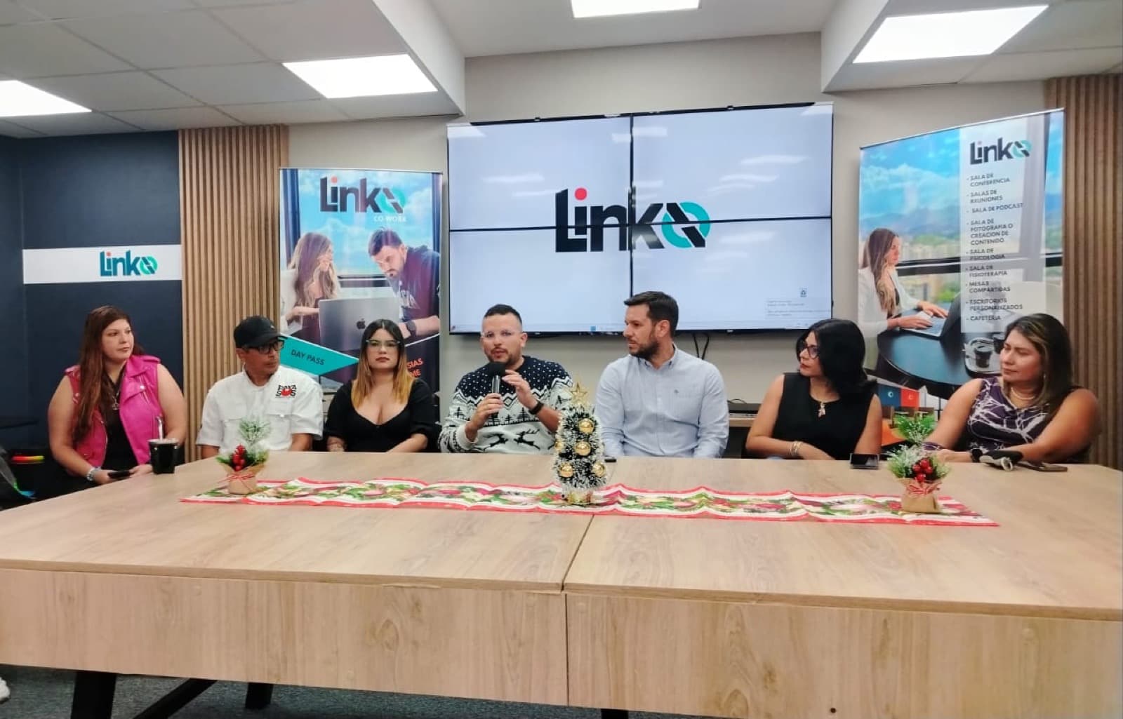 Rueda de prensa con mesa larga y branding Linko
